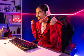 Host channel of smiling beautiful Asian girl streamer playing with raising fist up winning on...