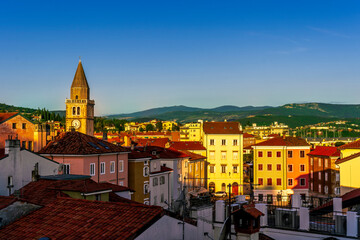 amazing evening town with church, tower with bell , yellow houses and beautiful hills with nice...