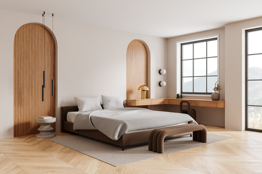 Stylish hotel bedroom interior with bed, work table and window. Mock up wall