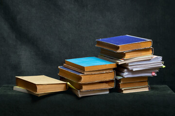 A stack of old books and notebooks on the table