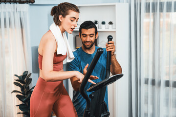 Athletic and sporty young couple or fitness buddy running on running machine together, home body workout exercise session as healthy sport lifestyle at home. Gaiety home exercise workout training.