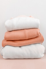 stack of wool sweaters in white and peach color