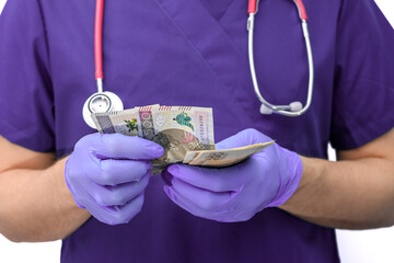 Lekarz chirurg liczy gotówkę w rękawiczkach  - obrazy, fototapety, plakaty