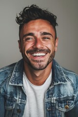 Fototapeta premium Handsome smiling, happy and pleased stoic man with positive vibes. Portrait of a joyful young man with beautiful hair and fashionable clothes.