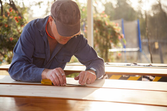 Man using chisel to smooth edges of timber