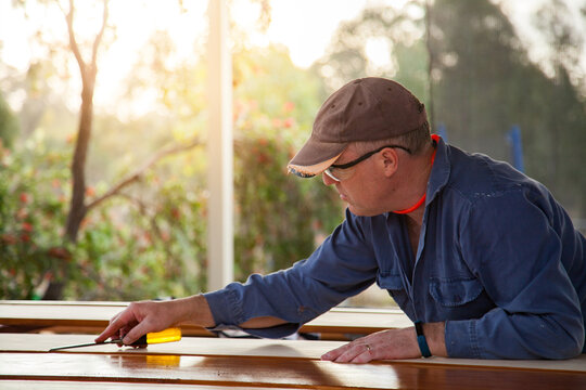Man using chisel to smooth edges of timber