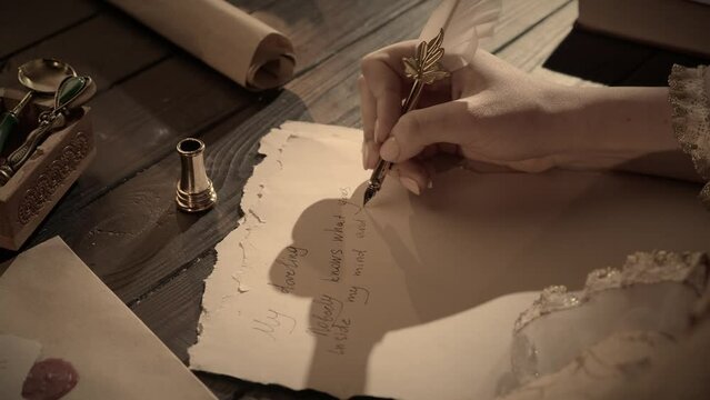 Antique female writing with old feather pen. Woman in renaissance dress writing a love letter with vintage quill pen on old parchment papers sheet.