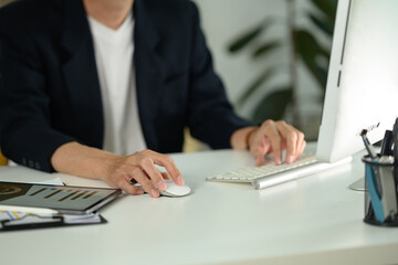 Cropped shot senior businessman typing on computer keyboard working at office desk