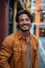 Handsome smiling, happy and pleased stoic man with positive vibes. Portrait of a joyful young man with beautiful hair and fashionable clothes.