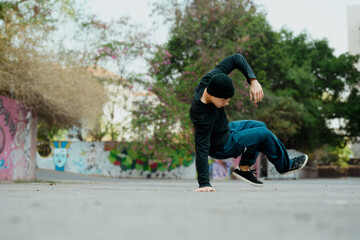 Full length shot of attractive male practicing b-boy dance on the street