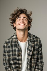 Fototapeta premium Handsome smiling, happy and pleased stoic man with positive vibes. Portrait of a joyful young man with beautiful hair and fashionable clothes.