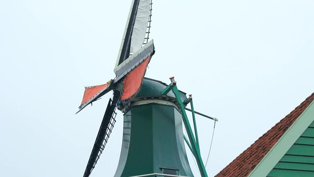 Plano medio de molino de viento holandes hist&oacute;rico en funcionamiento con detalle del techo en Zaanse Schans (Holanda)