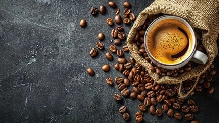 Fotobehang cup of coffee and coffee beans in a sack on dark background, top view © INK ART BACKGROUND