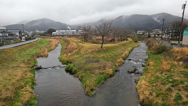 Yufuincho Kawakami with many Japanese house on the road with mountain background in winter Season - Footage Clip Travel Village in Yufuin Oita Japan
