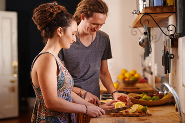 Home, happy couple and cutting orange in kitchen for healthy diet, nutrition or wellness. Man,...