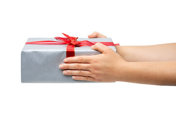 Close up of hand of woman holding gift box over Christmas tree background.