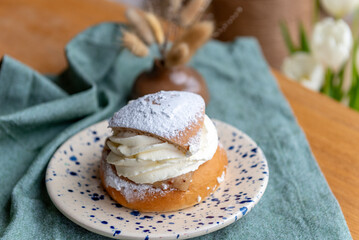 Typical Swedish semla with sweet cream on te blue textile