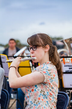 Teen girl playing flute with the town band, practicing for payout event