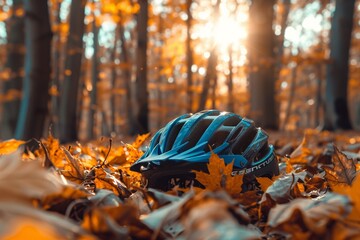 A bicycle helmet rests on the forest floor amidst fallen autumn leaves, with the warm, soft light...