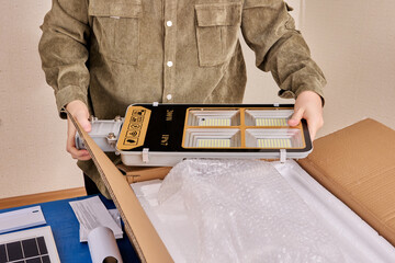 Unboxing new LED street light with solar panel and mounting bracket.