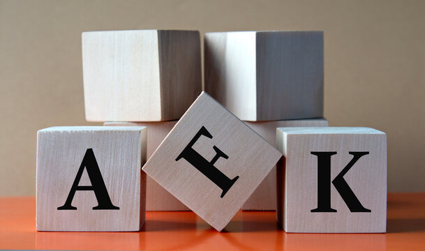 AFK - acronym on large wooden cubes on light brown background