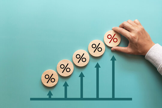 Financial, stocks and interest rate. Hand putting wood cube with percentage icon and arrow up for interest rate ,ranking ,financial stocks and GDP percent change. top view