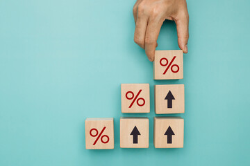 Financial, stocks and interest rate. Hand putting wood cube with percentage icon and arrow up for...