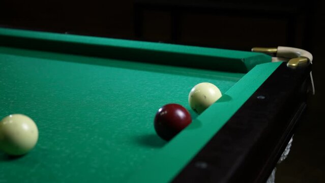 Young men playing American billiard poule close-up. Colorful balls on green billiards table .Billiard balls with numbers on a pool table. Billiards team sport.