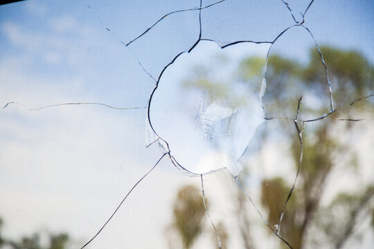 Vandalized window of building, smashed broken glass