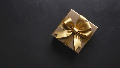 Gift box with a golden bow on a dark textured background
