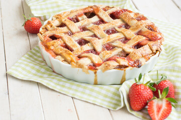 home made pie with rhubarb and strawberry on white background close up selective focus