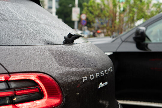 Shanghai, China, March 10, 2024: Porsche Macan SUV on city street. Back view of Porsche Macan  in the traffic jam. Porsche logo on the trunk