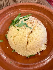 Lebanese cuisine. Plate of freshly made Couscous in a terracotta dish.  Taken in a restaurant.  
