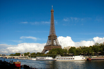 Fototapeta na wymiar view of the Eiffel Tower and the Seine Rver, Paris, France; white pleasure boats at a pier