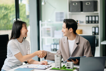 Real estate broker agent presenting and consult to customer to decision making sign insurance form agreement, home model,