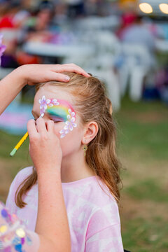 Pre-teen girl having face paint done at event