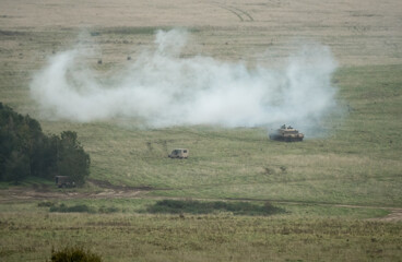 soldier commanding a British army Challenger 2 II FV4034 main battle tank in action on a military exercise, smoke grenade deployed