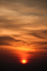 the sun rising through the clouds