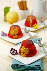 Jelly dessert with flowers and strawberries.