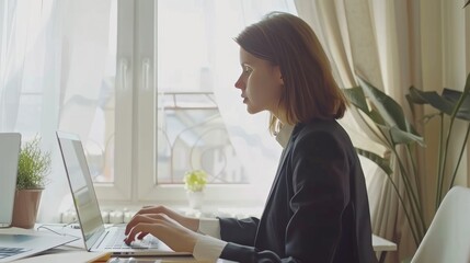 Attractive young woman in formal suit, using laptop computer having conversation on video call