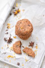 home made chocolate cookies with orange zest, chocolate chips and spices perfect for christmas on grey wooden background close up selective focus