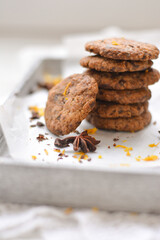 Fototapeta na wymiar home made chocolate cookies with orange zest, chocolate chips and spices perfect for christmas on grey wooden background close up selective focus