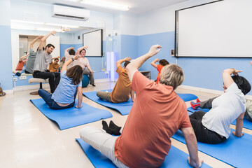 Yoga instructor guides diverse participants, some with mental disabilities.