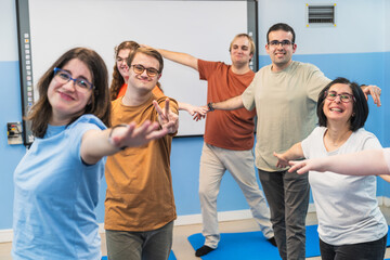 Yoga students with Down Syndrome extend open arms in a gesture of inclusive joy.