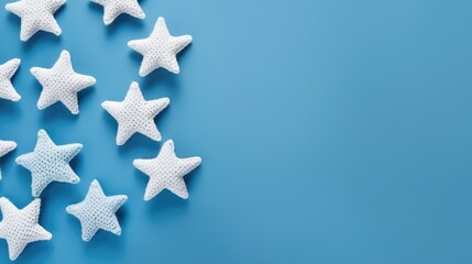 Obraz premium Knitted stars on a monochrome colored background, top view, with space for text. Greeting card, hobby, knitting, children's toy.