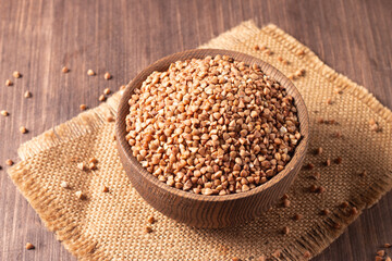 Buckwheat groats on wooden background. Healthy cereal concept.  