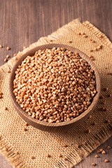 Buckwheat groats on wooden background. Healthy cereal concept.  