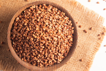 Buckwheat groats on wooden background. Healthy cereal concept.  