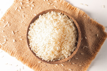 Uncooked white rice in a wooden bowl. Healthy cereal concept.  