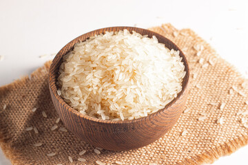 Uncooked white rice in a wooden bowl. Healthy cereal concept.  